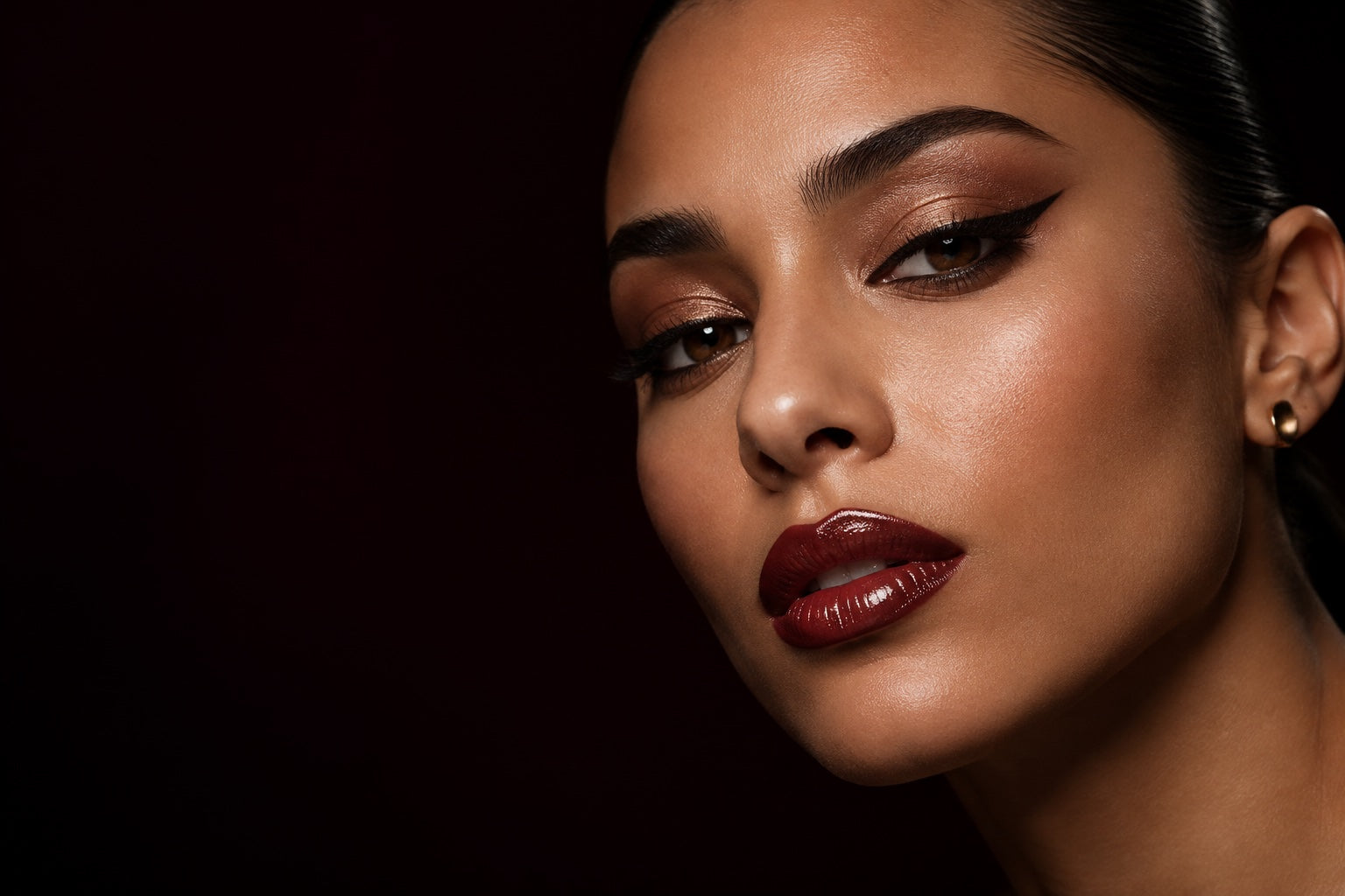 Bronze eye makeup and a bold burgundy lip